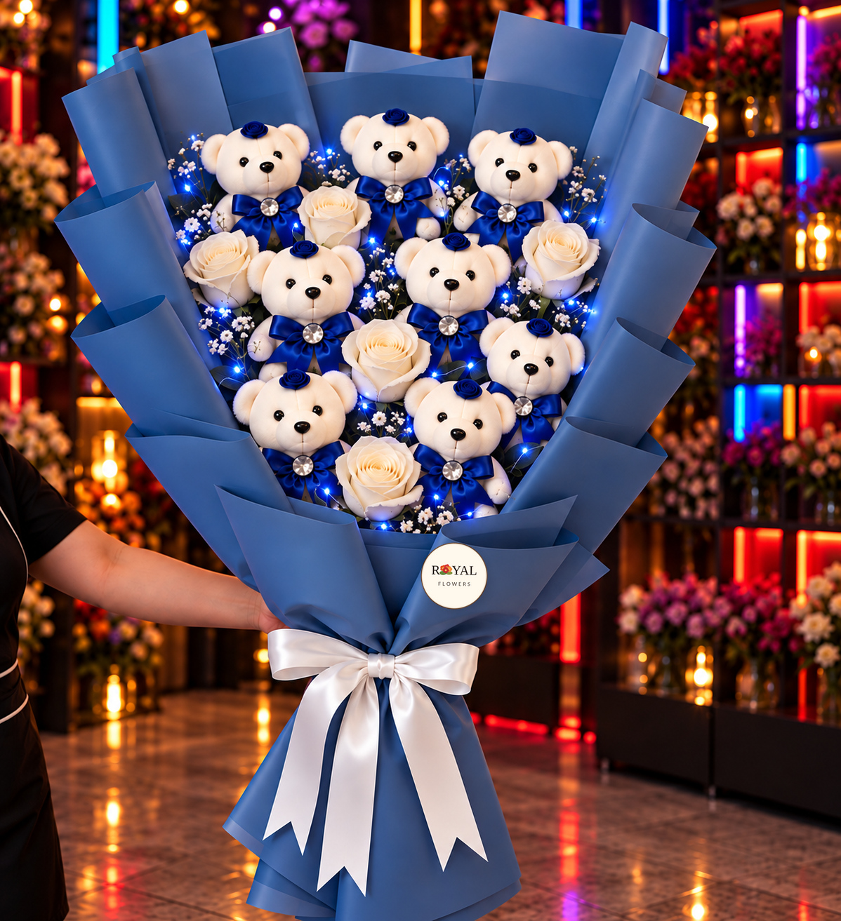 Mavi Işıklı Ayıcık Buketi(1) - Royal Flowers Logolu LED'li mega boy mavi elbiseli 7'li peluş ayıcık buketi, 5 beyaz gül ve mavi LED ışıklı Royal Flowers
